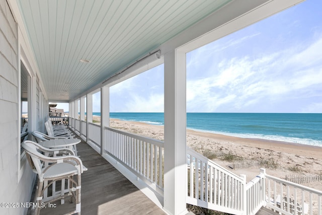 deck featuring a view of the beach and a water view