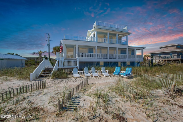 back house at dusk with a balcony