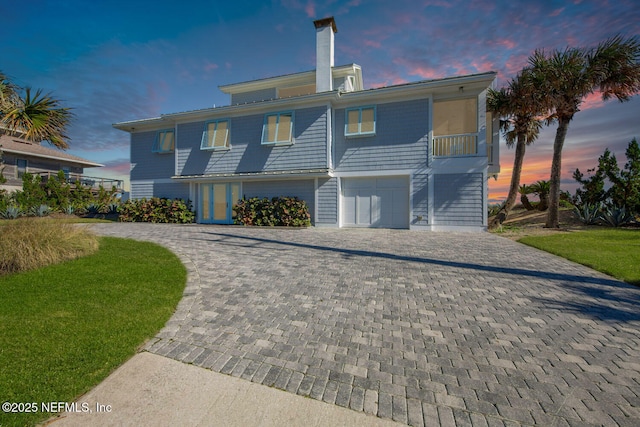 back house at dusk with a garage