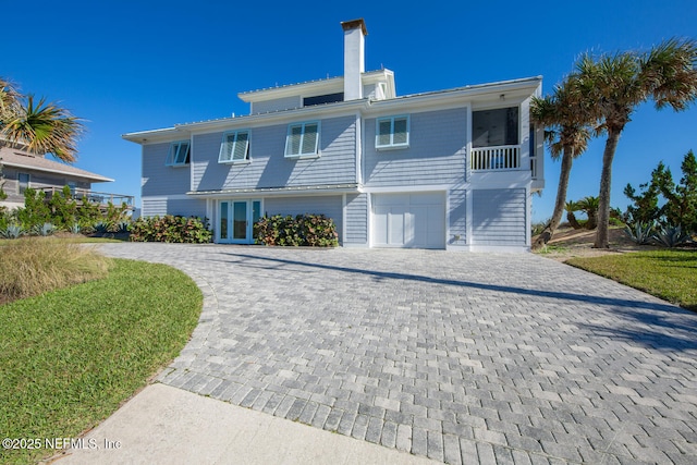 back of house with french doors and a garage