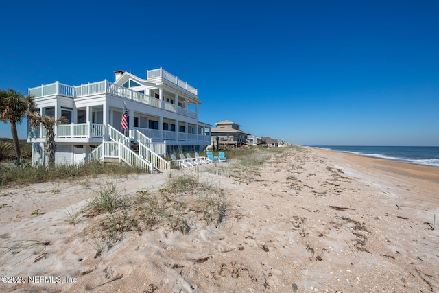 back of property with a beach view and a water view