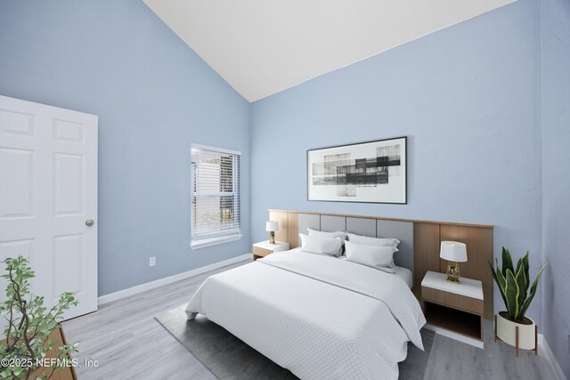 bedroom featuring high vaulted ceiling and light wood-type flooring