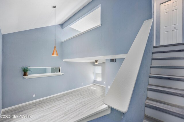 stairway featuring hardwood / wood-style flooring, vaulted ceiling with beams, and ceiling fan