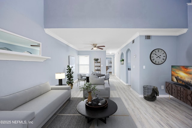 living room with light hardwood / wood-style flooring, ceiling fan, and ornamental molding