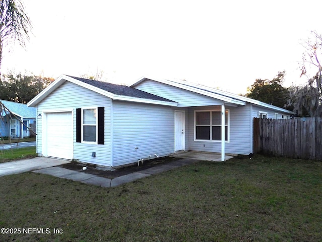 rear view of property with a lawn and a garage