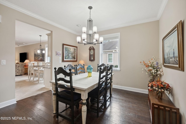 dining area featuring dark hardwood / wood-style flooring, ornamental molding, and a chandelier