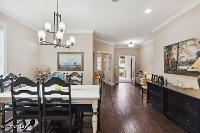 dining space with dark hardwood / wood-style floors, crown molding, and an inviting chandelier