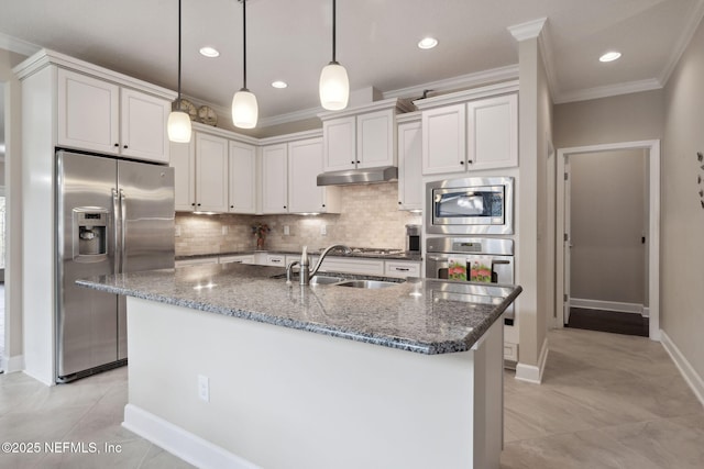 kitchen with white cabinets, sink, dark stone countertops, decorative light fixtures, and stainless steel appliances