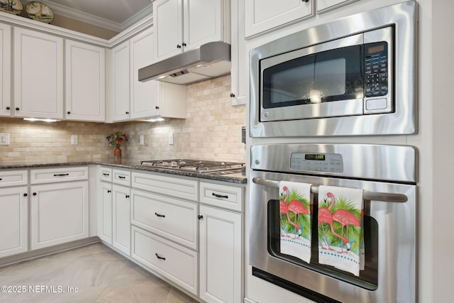 kitchen with backsplash, white cabinetry, dark stone counters, and appliances with stainless steel finishes