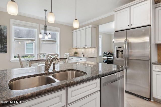 kitchen with white cabinets, decorative light fixtures, sink, and appliances with stainless steel finishes