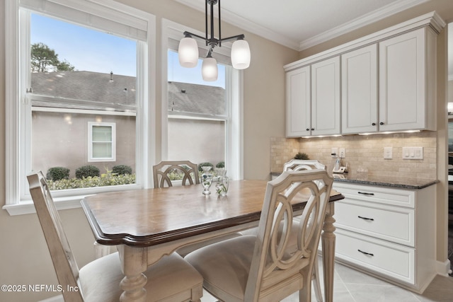 dining space with an inviting chandelier, crown molding, and light tile patterned flooring