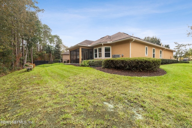 back of house with a lawn and a sunroom