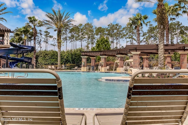 view of pool with a pergola and a water slide