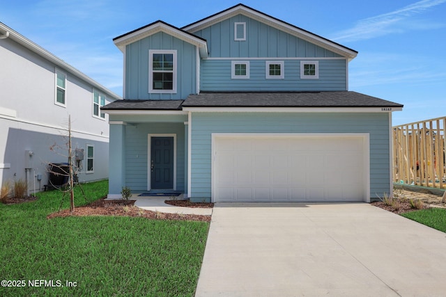 view of front of home featuring an attached garage, fence, driveway, board and batten siding, and a front yard