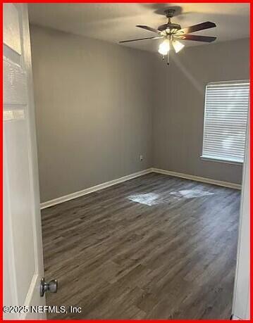 unfurnished room with dark hardwood / wood-style floors and ceiling fan