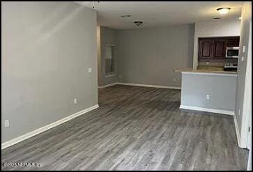 unfurnished living room featuring dark hardwood / wood-style flooring