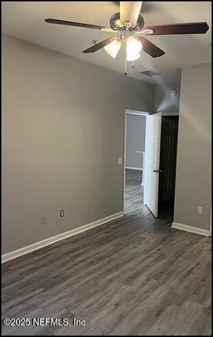 empty room featuring ceiling fan and dark hardwood / wood-style floors