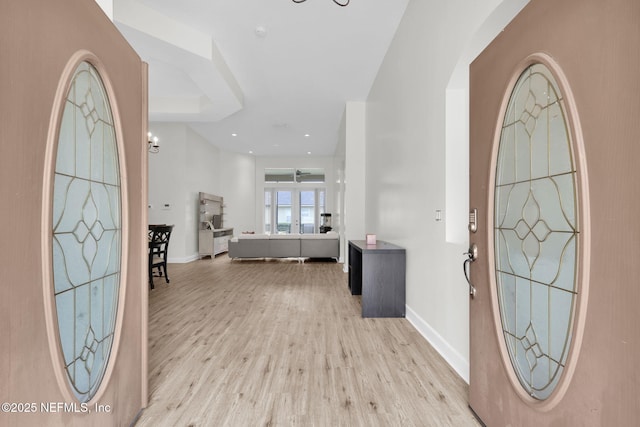 entryway featuring a chandelier and light hardwood / wood-style floors