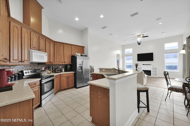 kitchen featuring light tile patterned flooring, appliances with stainless steel finishes, backsplash, and sink