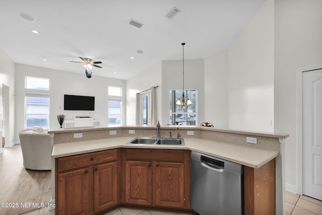 kitchen with dishwasher, sink, hanging light fixtures, an island with sink, and ceiling fan with notable chandelier