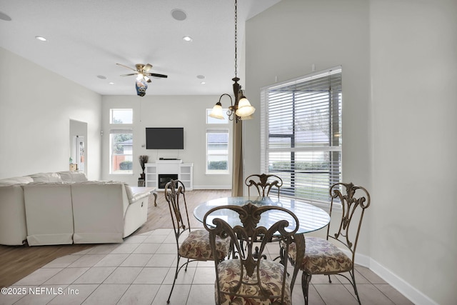 dining room with ceiling fan with notable chandelier and light tile patterned flooring