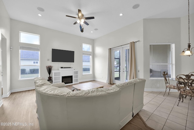 living room with ceiling fan, light tile patterned flooring, and a wealth of natural light