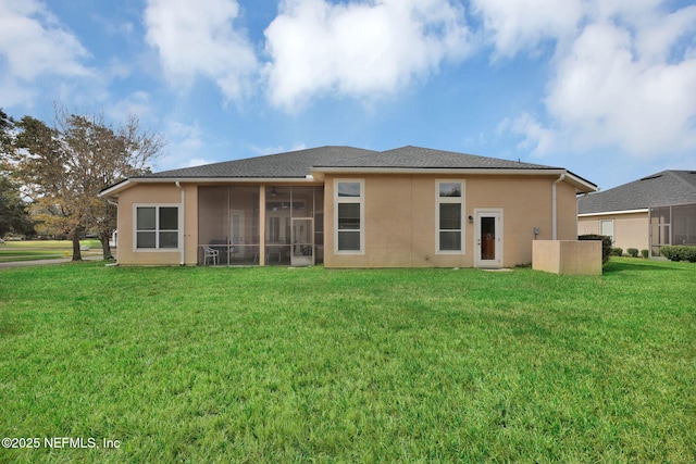 rear view of property with a lawn and a sunroom