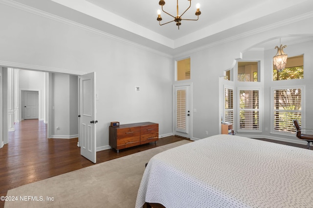 bedroom with dark hardwood / wood-style flooring, a high ceiling, and a chandelier