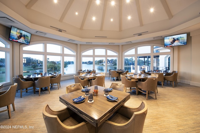 carpeted dining area with a towering ceiling