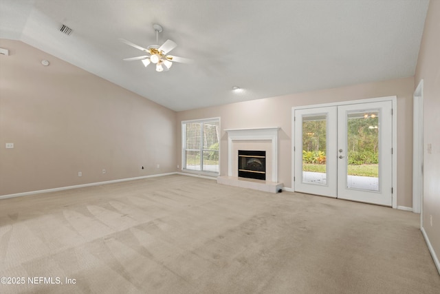 unfurnished living room featuring french doors, light colored carpet, ceiling fan, and lofted ceiling