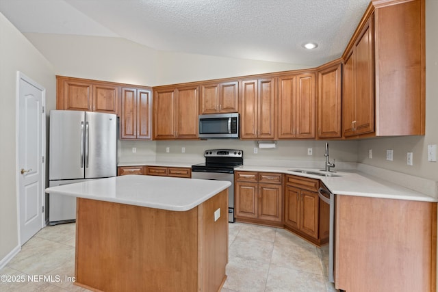 kitchen with sink, a center island, stainless steel appliances, a textured ceiling, and vaulted ceiling