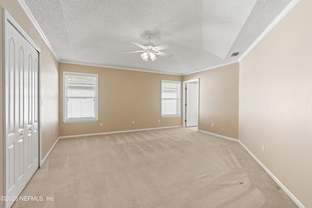 unfurnished bedroom featuring multiple windows, light colored carpet, ceiling fan, and ornamental molding