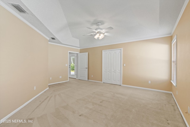 carpeted empty room featuring a textured ceiling, ceiling fan, and crown molding