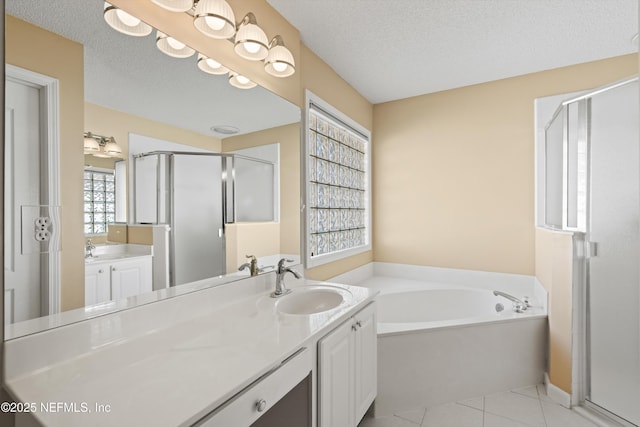 bathroom with vanity, shower with separate bathtub, a textured ceiling, and tile patterned floors