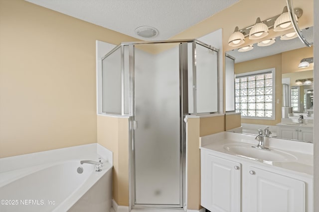 bathroom with vanity, shower with separate bathtub, and a textured ceiling