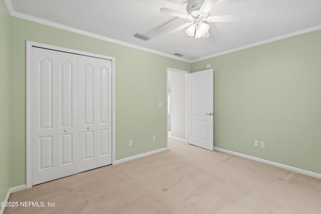 unfurnished bedroom featuring a textured ceiling, a closet, ceiling fan, and light colored carpet