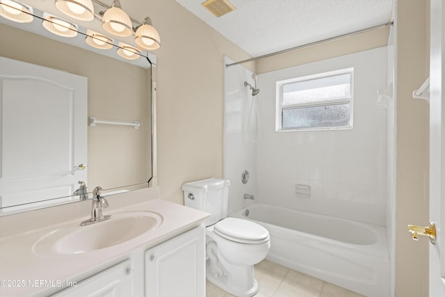 full bathroom with tile patterned floors, vanity, a textured ceiling, toilet, and tiled shower / bath