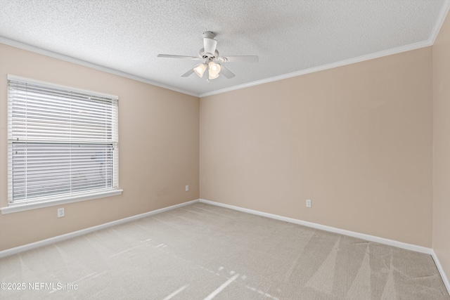 carpeted spare room with a textured ceiling, ceiling fan, and crown molding