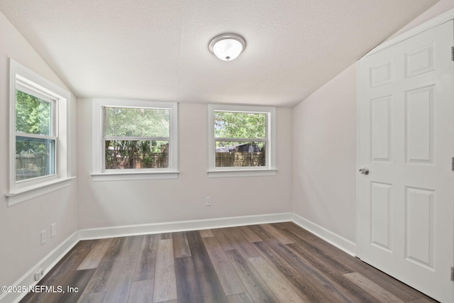 unfurnished room with a textured ceiling, lofted ceiling, and dark hardwood / wood-style floors