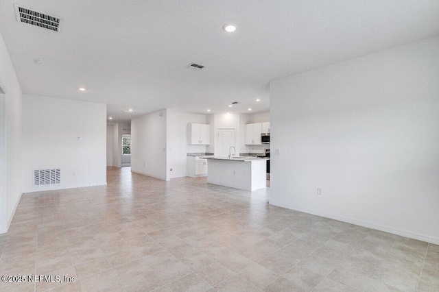 unfurnished living room featuring sink