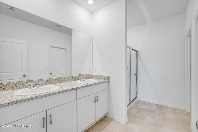 bathroom featuring a shower with door and vanity