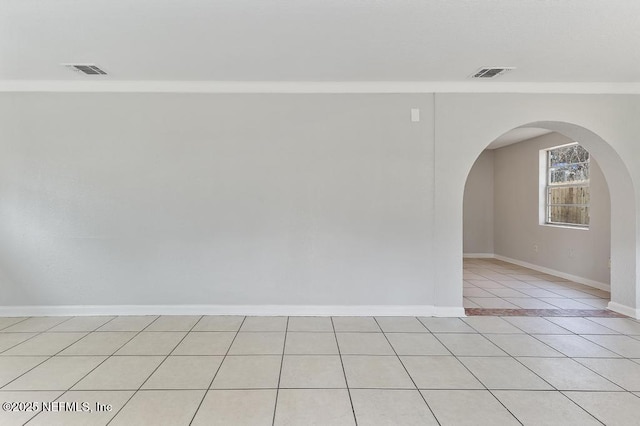 empty room featuring light tile patterned floors and ornamental molding