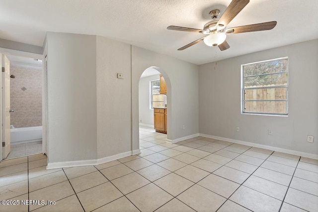 tiled spare room with ceiling fan