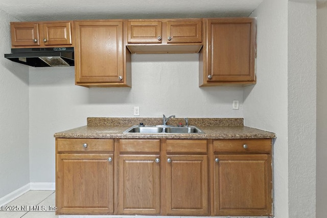 kitchen with ventilation hood, light tile patterned floors, and sink