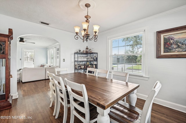 dining space with a textured ceiling, crown molding, dark hardwood / wood-style floors, and ceiling fan with notable chandelier