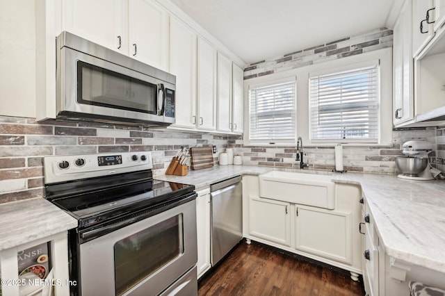 kitchen featuring light stone countertops, white cabinets, and stainless steel appliances