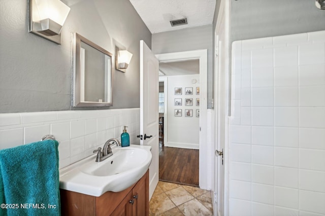 bathroom with tile patterned floors, vanity, and a textured ceiling