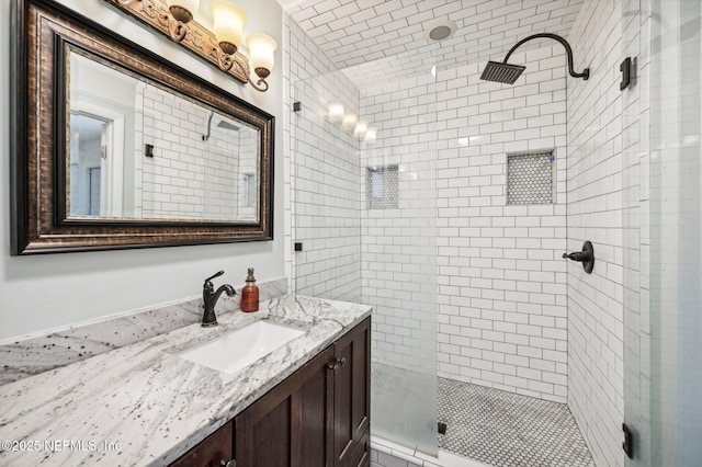 bathroom featuring a tile shower and vanity