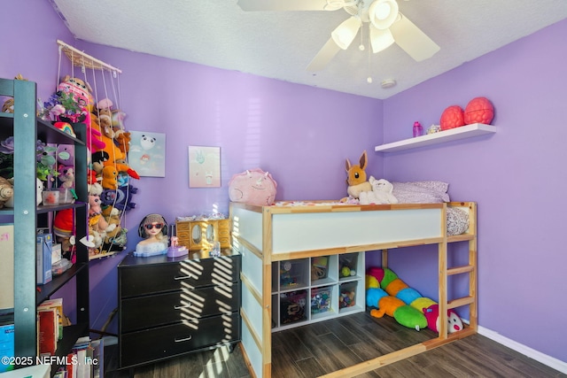 bedroom with ceiling fan, dark wood-type flooring, and a textured ceiling