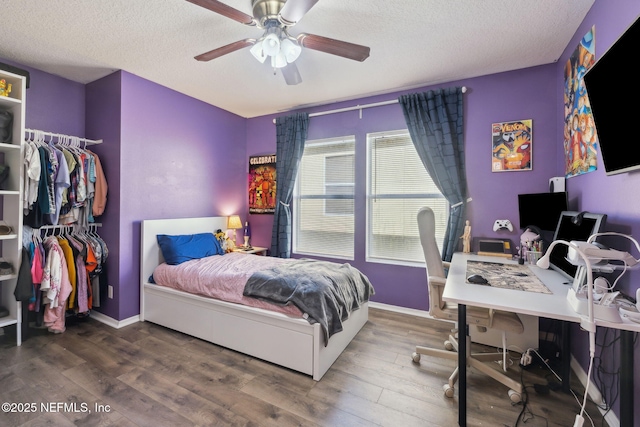 bedroom featuring hardwood / wood-style flooring, ceiling fan, and a textured ceiling